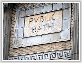 old roman stone carved with the words public bath