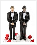 two groom figures standing on a white wedding cake