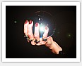 woman's hand holding a glowing chrystal ball