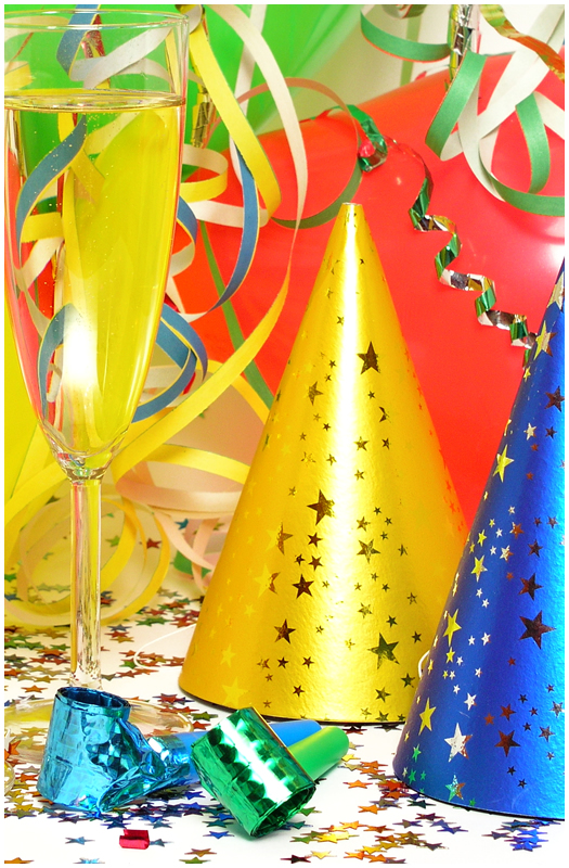 colorful birthday party hats and glass of champagne
